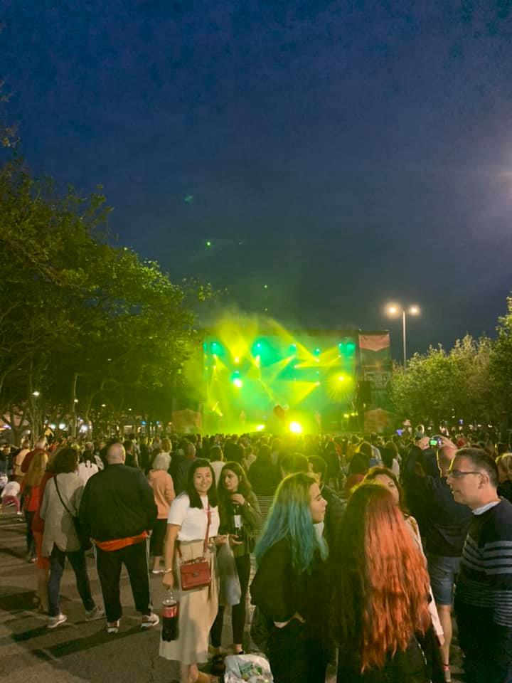 A night shot of a crowd of people and lights on stage