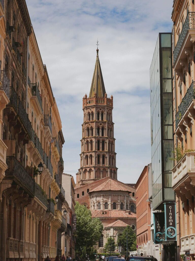 A street in Toulouse with the tower of the Saint-Sernin Basilica in view.