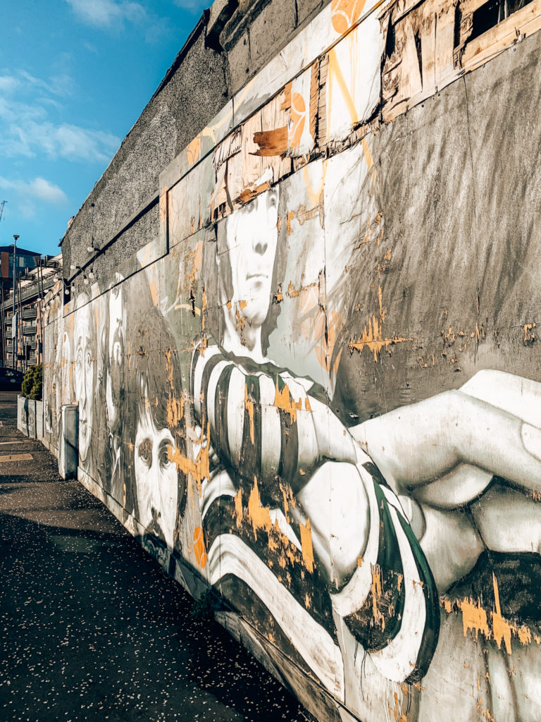 a section of the clutha bar mural on the glasgow mural trail which shows several famous faces who visited the bar in its prime