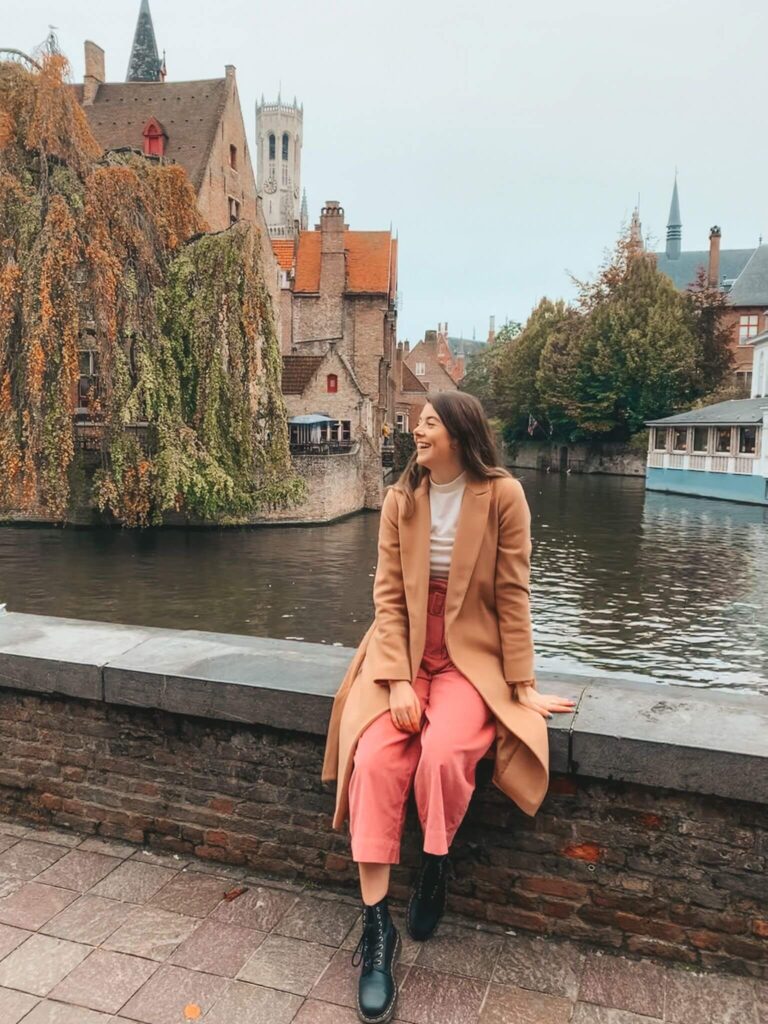 A girl sits at Quay of the Rosary in Bruges, Belgium.