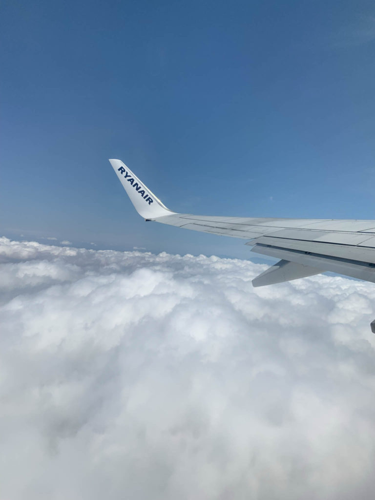 The view from a Ryanair plane with clouds and the plane wing