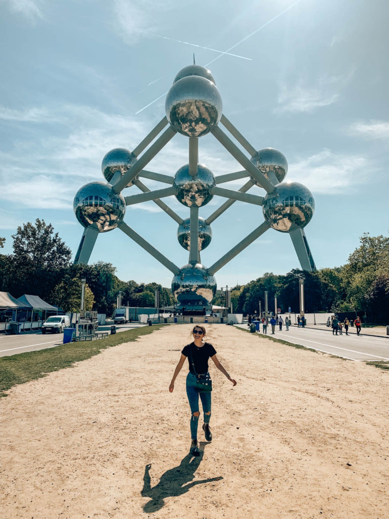 a girl stands in front of the Atomium in Brussels