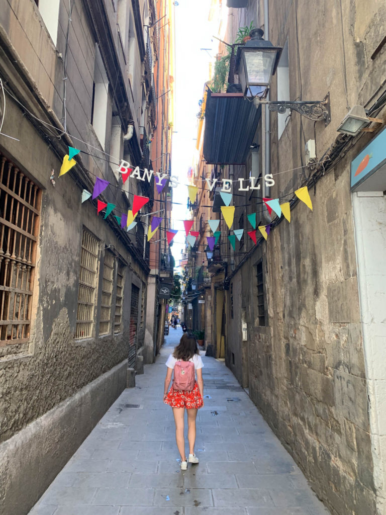 a girl walks down a cute stone street in Barcelona