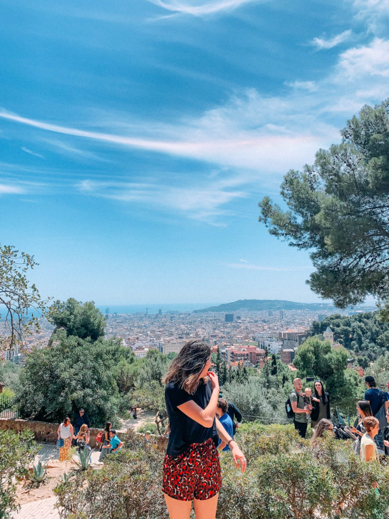 Park Guell Barcelona: a girl in the forefront with views over Barcelona in the background