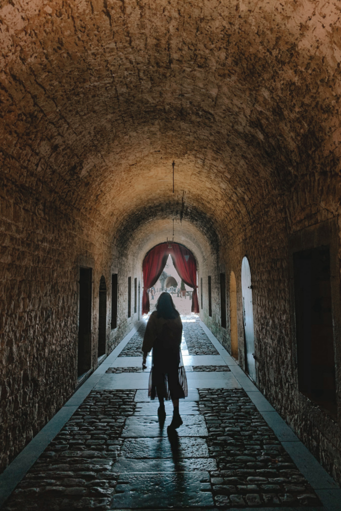 the shadow of a girl standing in a brick tunnel inside the Dinant citadel