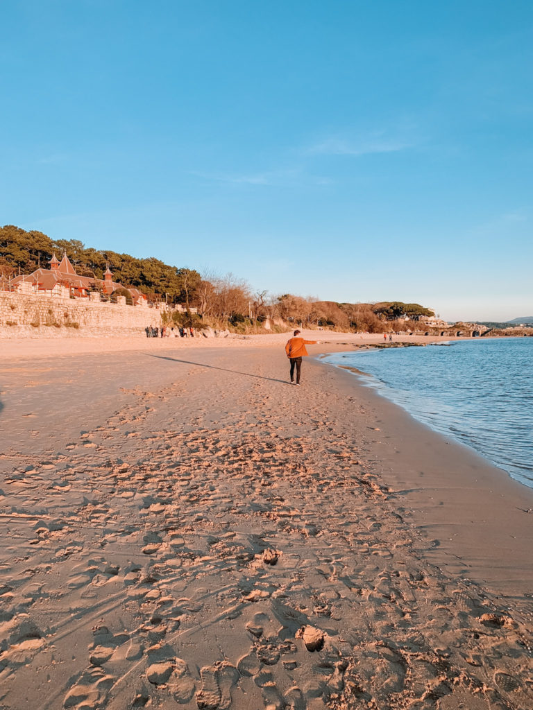 Playa de la Magdelena in Santander at sunset, a man walks away from the camera and points out to sea