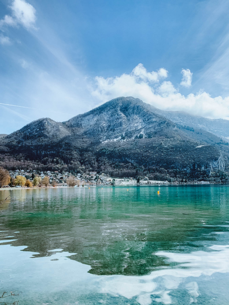 a mountain and its reflection in Lake Annecy