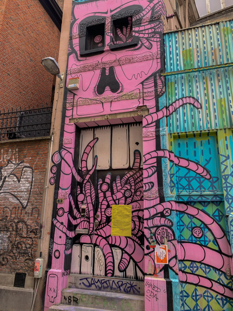 Pink graffiti covers a building on Antwerp's graffiti street