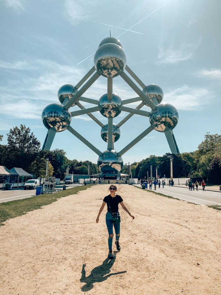 A girl smiles below the Atomium museum in Brussels, Belgium