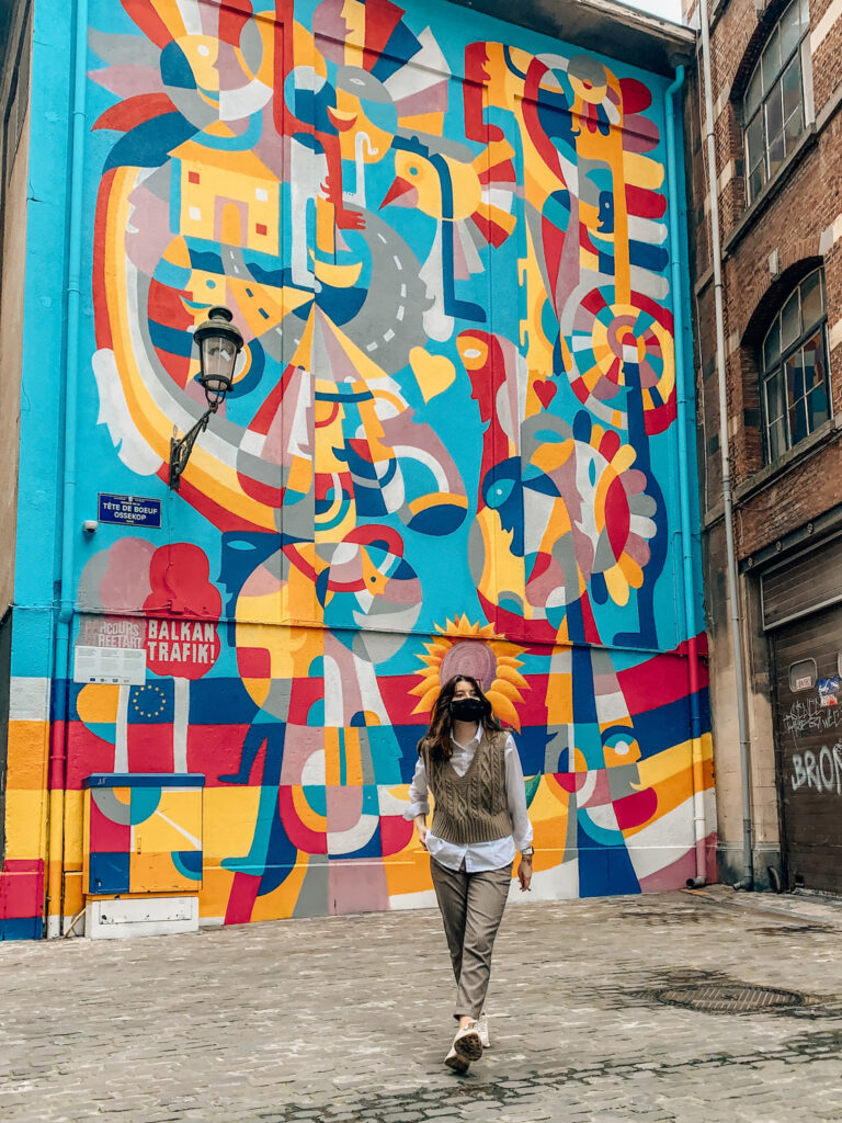A girl walks in front of the 2019 balkan trafik mural in Brussels, Belgium
