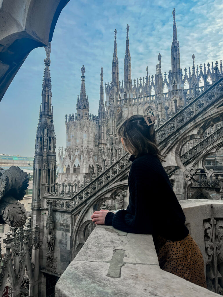 A girl looks out over the spires of the Milan Duomo