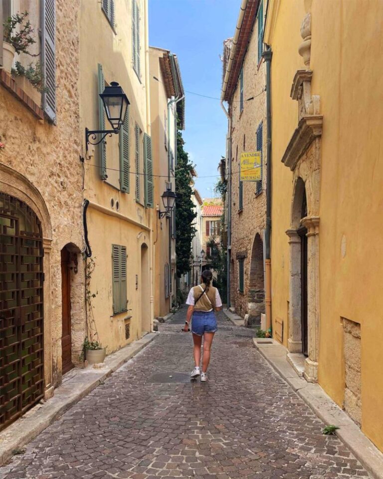 a girl walks through the old town of Antibes, French Riviera