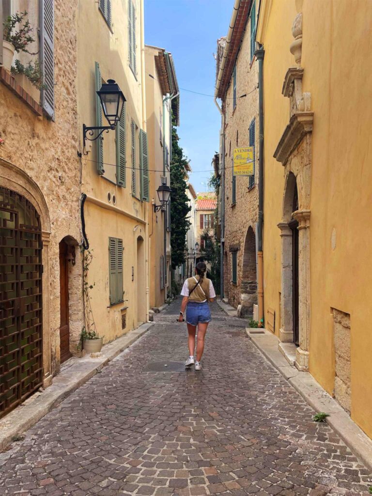 A girl walks through a street in the old town of Antibes, France