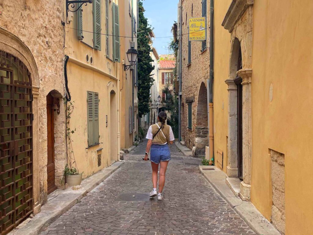 A girl walks through a street in Antibes old town