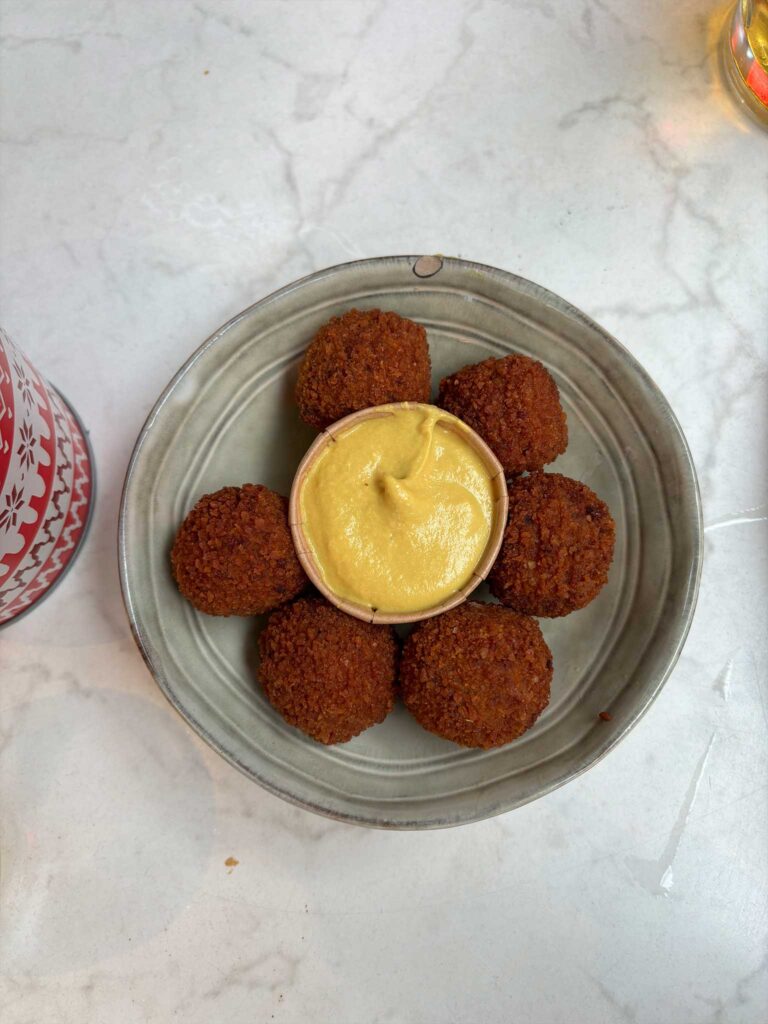 A plate of bitterballen with mustard, some of the best street food in Amsterdam