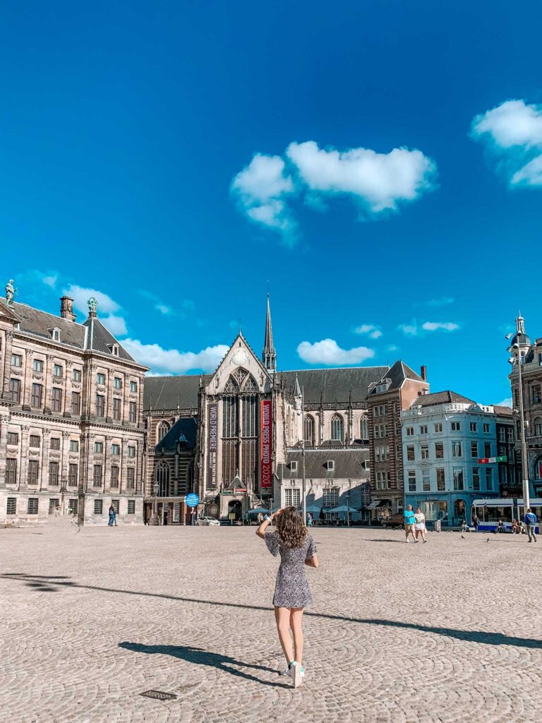A girl stands in an empty Dam Square in Amsterdam