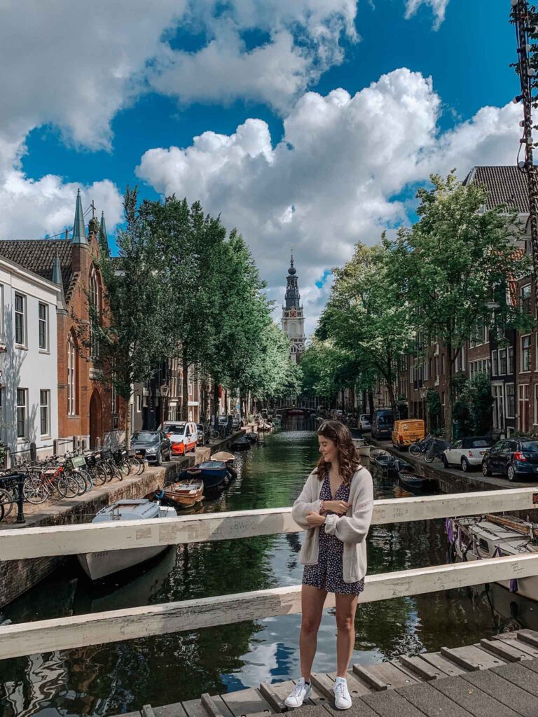 A girl stands in front of a canal in Amsterdam