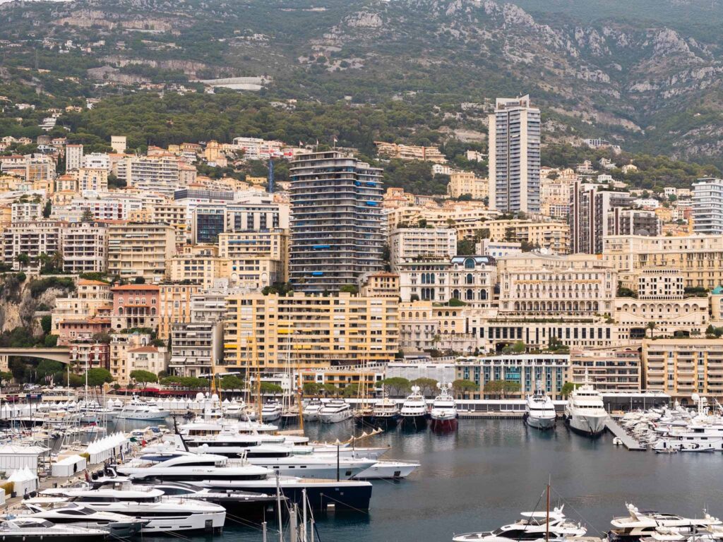 Boats and yachts docked in Port Hercule, with Monaco's cityscape in the background