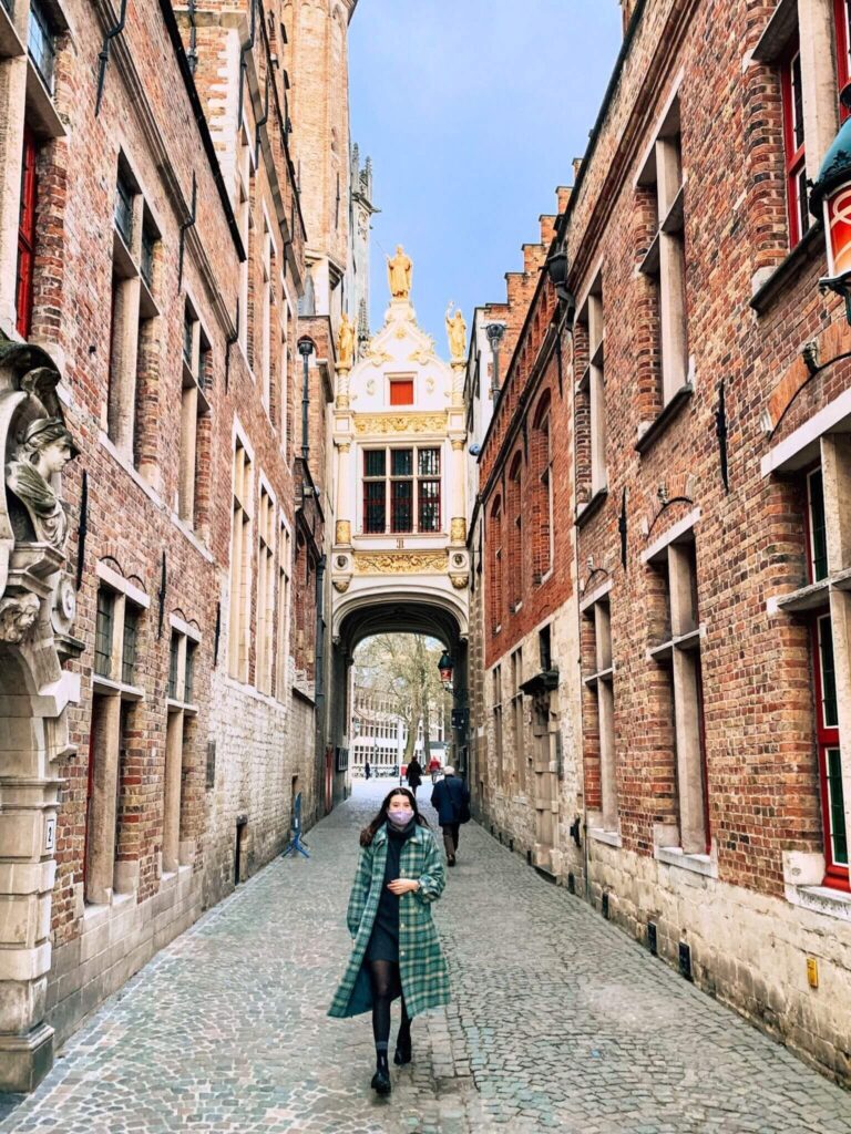 A girl stands on Blinde-Ezelstraat in Bruges.