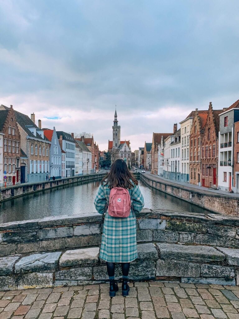 A girl stands on Koningsbrug looking out over Jan Van Eyck Square.