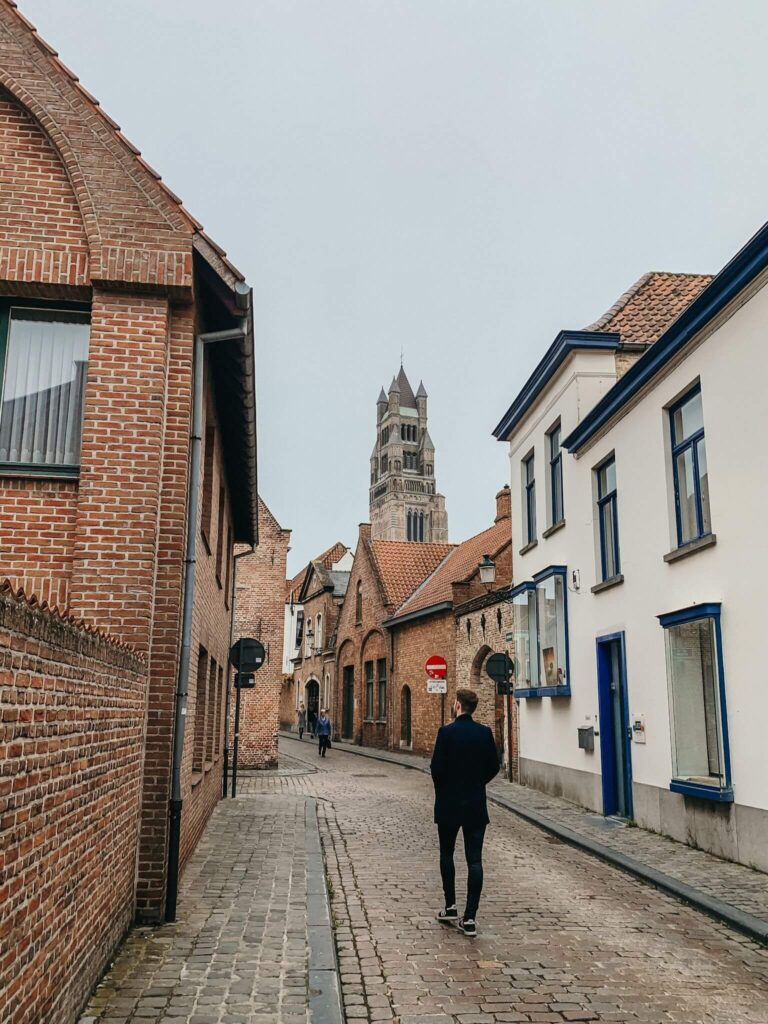 A man walking down Oostmeers in Bruges.