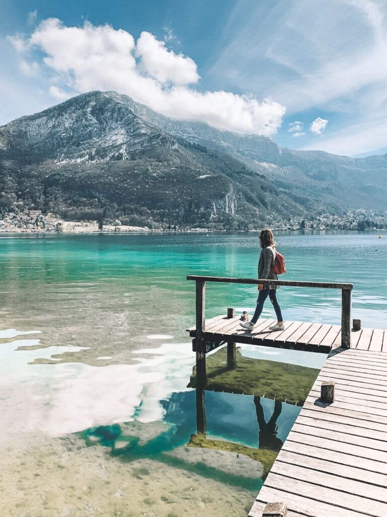 Girl on a wooden pier over Lake Annecy.