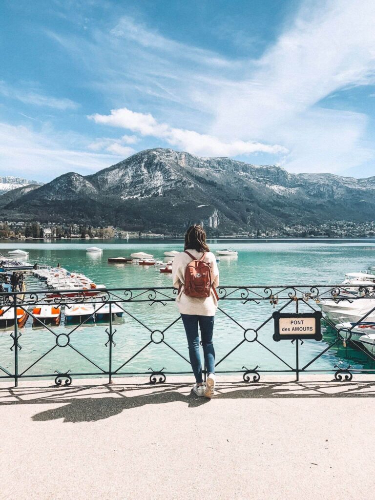 Girl standing on Pont des Amours looking out to Lake Annecy.