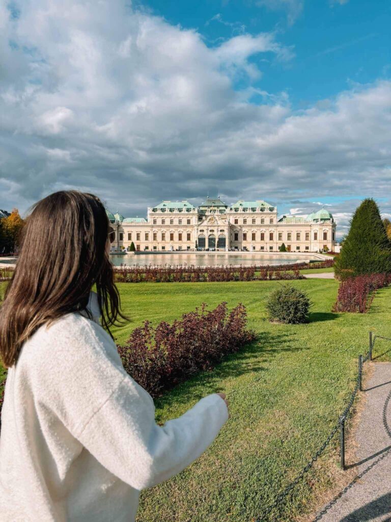 A girl standing in front of Belvedere Palace in Vienna