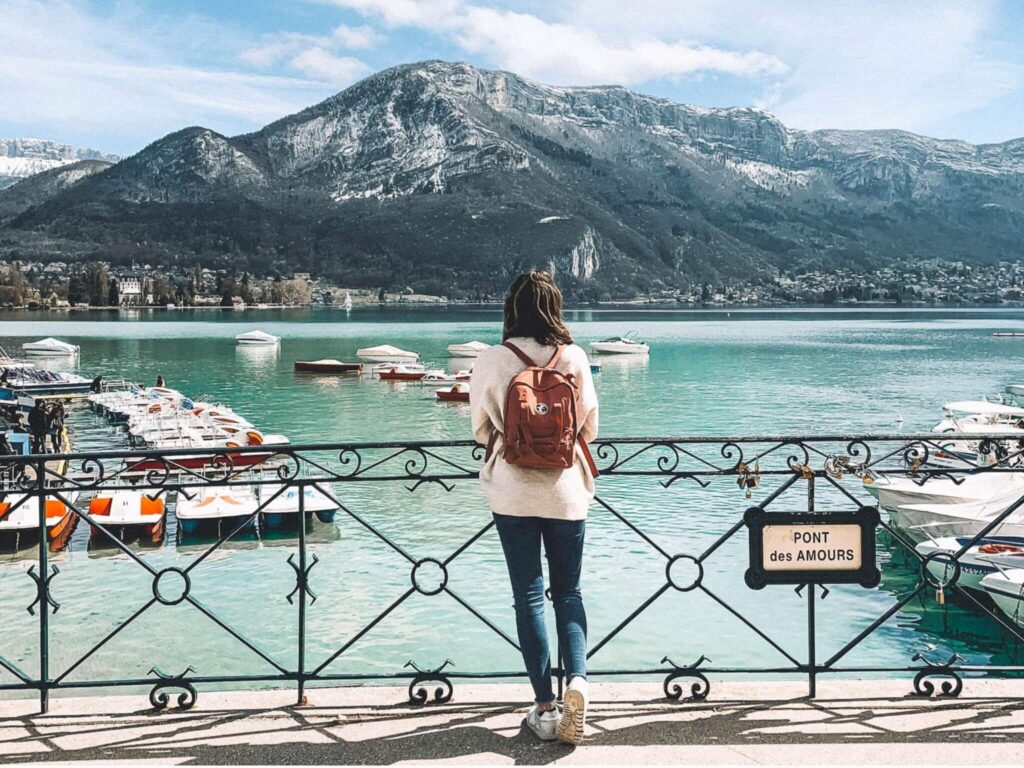 Girl standing on Pont des Amours looking out to Lake Annecy.